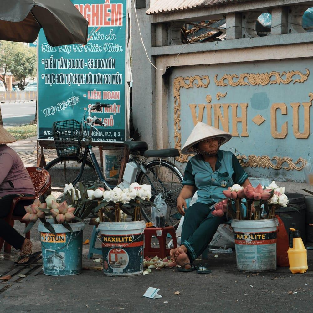 Vendeuse de fleurs et de produits frais sur un marché vietnamien