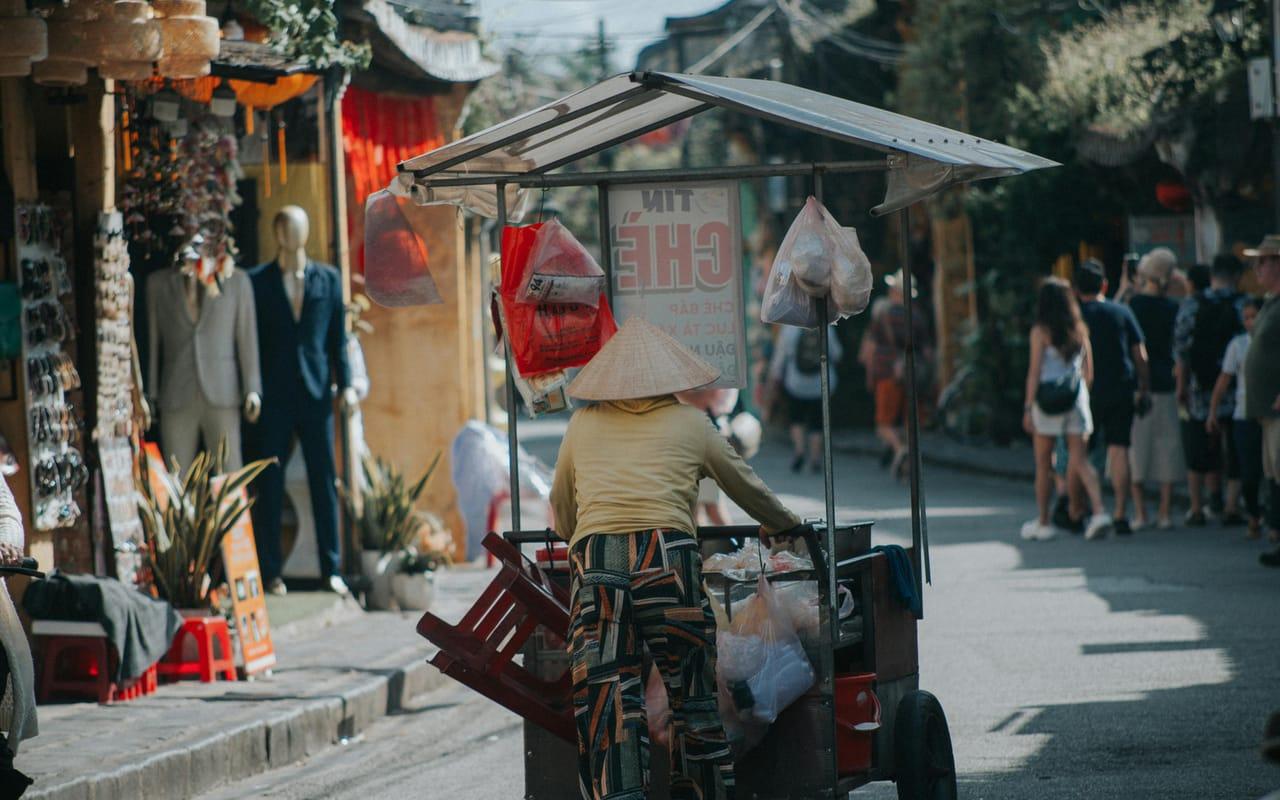Marché de rue vietnamien animé, vendeurs ambulants et chapeaux coniques
